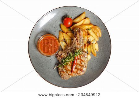 Fried Meat With Garnish Of Pepper, Zucchini, Tomato And Corn With Ajika Sauce Served On A Gray Plate