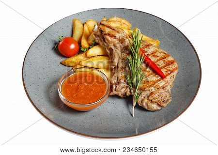 Fried Meat With Garnish Of Pepper, Zucchini, Tomato And Corn With Ajika Sauce Served On A Gray Plate