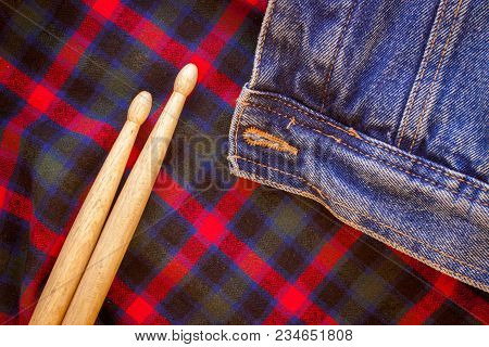 Drum Sticks Lie On A Scottish Cage And Jeans