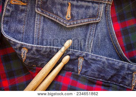 Drum Sticks Lie On A Scottish Cage And Jeans