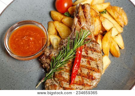 Fried Meat With Garnish Of Pepper, Zucchini, Tomato And Corn With Ajika Sauce Served On A Gray Plate