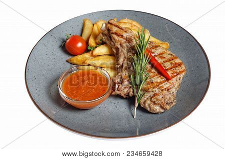 Fried Meat With Garnish Of Pepper, Zucchini, Tomato And Corn With Ajika Sauce Served On A Gray Plate