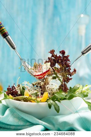 Bowl With Fresh Springtime Vegetarian Salad Of Raw Vegetables And Microgreen On Blue Background. Two