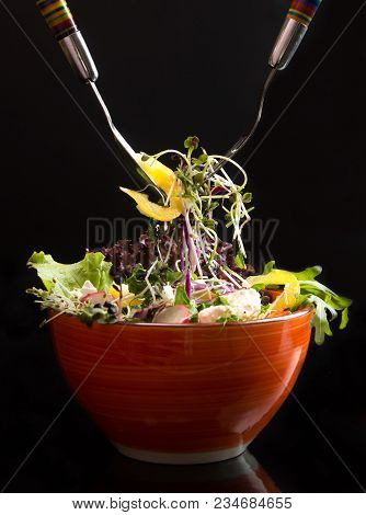 Bowl With Fresh Vegetarian Salad Of Raw Vegetables And Microgreen On Black Background. Two Forks. Sa