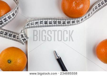 Mandarins, Notepad, Centimeter Tape On A White Background