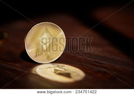 Golden Ethereum Blockchain Cryptocurrency With Its Shadow On Wooden Table, Close-up, Macro, Selectiv