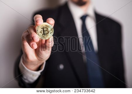Golden Bitcoin In A Man Hand, Digitall Symbol Of A New Virtual Currency. Man Recived Money From Bitc