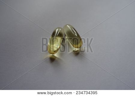 Two Yellow Softgel Capsules Of Fish Oil