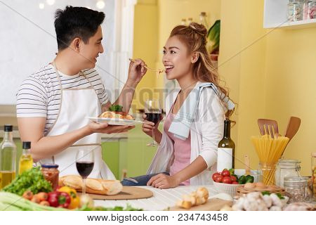 Young Asian Man Feeding His Pretty Girlfriend With Spaghetti He Made