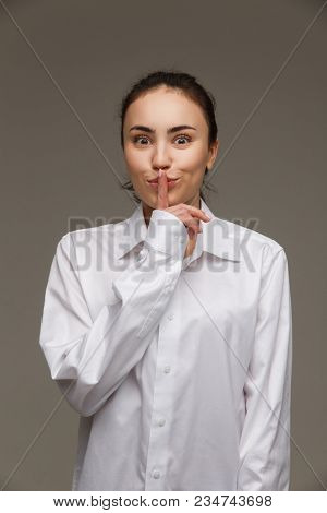 Beautiful Girl In A White Shirt Shows Emotions. On A Light Background.