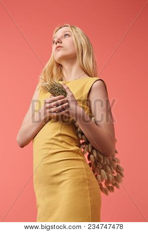 Attractive Young Woman With Bouquet Of Lagurus Looking Up Isolated On Red