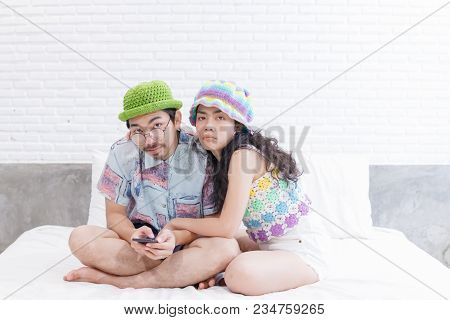 Couple Asian Man And Woman With Woolhat Together Funny Moment On White Bed