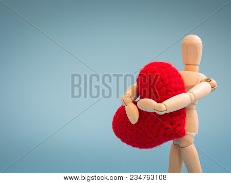 Wooden Puppet Standing And Holding A Red Heart On The Blue Screen Background. Wooden Puppet Holding 