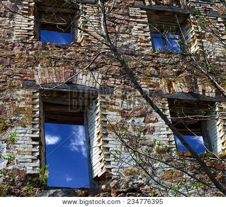 Brick Wall Of Old Destroyed House With Broken Windows