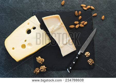 An Appetizing Solid Cheese On A Black Plate On A Gray Stone Background