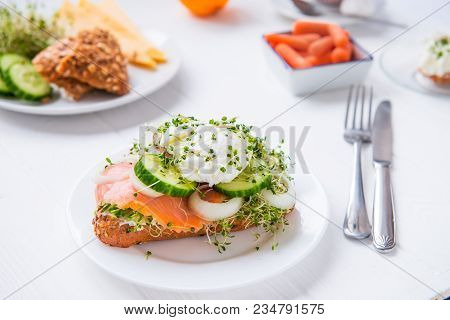 Cereal Bun With Egg Benedict, Smoked Salmon, Sprout Micro Greens, Onion And Cucumber Slices, Cream C