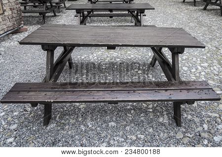 Focus On Wet Old And Awry Wood Tavern Style Table