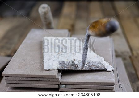 Laying And Cutting Tiles. Tools And Building Materials At A Working Position. Tiles For Industrial A