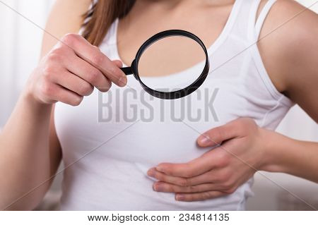 Woman Holding Magnifying Glass Showing Breast Care Concept
