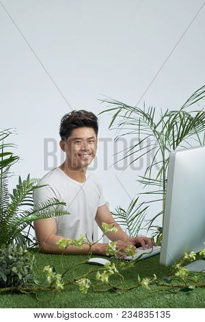 Portrait Of Smling Handsome Businessman Surrounded Himself With Green Plans