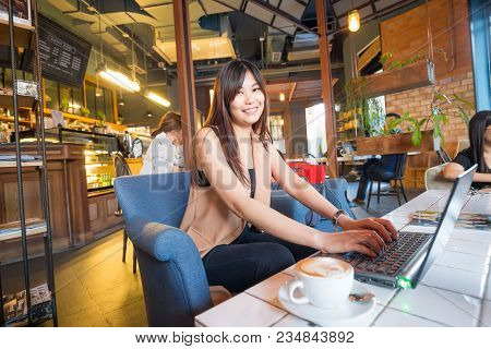 Business Women Working With Laptop In Cafe And Drink Latteart