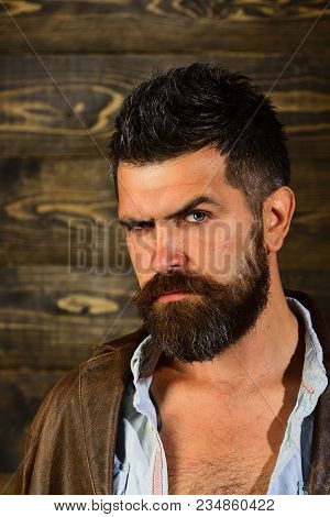 Serious Hipster In Barbershop, Look. Man With Beard And Mustache On Wooden Background. Barber And Ha