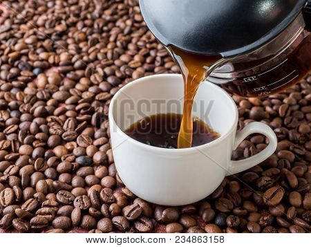 Cup And Pot Of Coffee On Coffee Beans Background