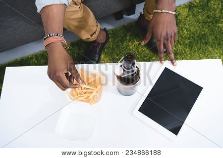 Africam American Man Eating French Fries With Beer On Table With Digital Tablet