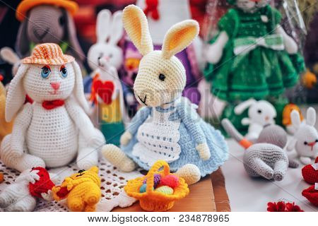 Three Handmade Knitted Hens And Rabbits On Beige Background As Easter Decoration