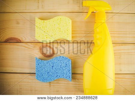 Cleaning House Or Office Concept. Yellow Plastic Bottle With Spayer And Sponges On A Natural Wooden 