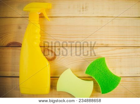 Cleaning House Or Office Concept. Yellow Plastic Bottle With Spayer And Sponges On A Natural Wooden 