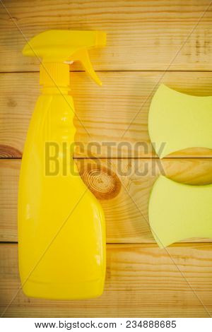 Cleaning House Or Office Concept. Yellow Plastic Bottle With Spayer And Sponges On A Natural Wooden 