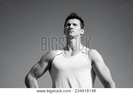 Man Bodybuilder Posing On Blue Sky. Fitness Model With Muscular Hands, Biceps, Triceps, Strong Muscl