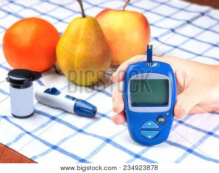 Diabetes Checking Blood Sugar Level. Woman Using Lancelet And Glucometer At Home.
