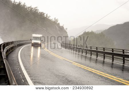 White Caravan Driving In A Very Bad Weather Condition On A Bridge Under The Langfoss Waterfall In No
