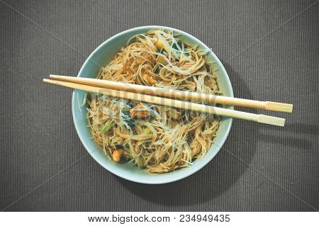 Bowl Of Asian Food With Tofu Eaten By Chop Sticks