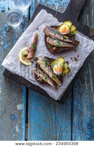 Vodka And A Set Of Sandwiches With Sprats On A Wooden Background. Top View. Copy Space.