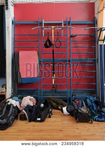 Sports Equipment And Gymnastics Mats Hang On The Wall Bars In The Gym. Near The Wall Bars Are Bags O