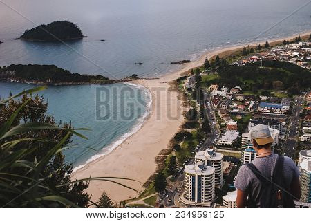 A Man Looking Out Over A City And The Ocean
