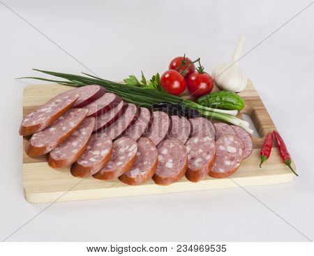 Still Life With Sliced Smoked Sausage Greens And Tomatoes On A White Background. Can Be Used For Ban