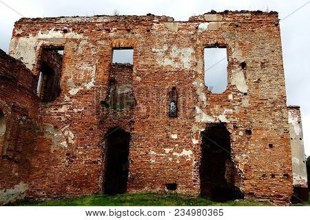 An Old Broken Brick Wall With Cracks. Ruined Wall Of The Old Cathedral.