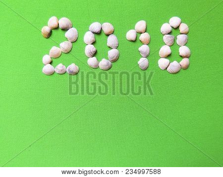 Year Laid Out Of Seashells On A Green Background. The Concept Of Travel, Tourism