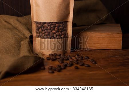 Blank Brown Kraft Paper Pouch Bag With Coffee Beans In Transparent Window On Wooden Background. Tren