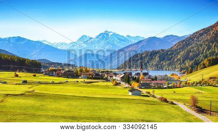 Magnificent Autumn View Of St.valentin Village And Haidersee (lago Della Muta) Lake With Ortler Peak