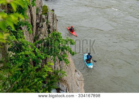 Two Men On Kayaks Paddlying On The River At Great Falls National Park, Virginia