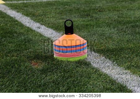 Cones In Football Field. Coath Arranged Colorful Markers In Trainning Grassfield Of Football Soccer