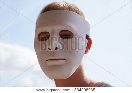 Mummery. A Man In A White Mask. In The Background A Sunny Sky.