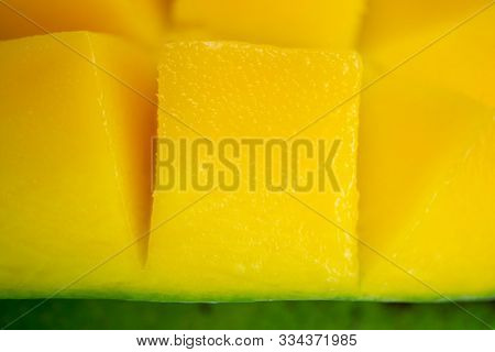 Close Up Dice Yellow Mango Cut Into Cubes. Macro Shot Background. Rip Exotic Tropial Fruit Slice Cut
