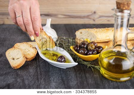 The Bread Dipped In Olive Oil With Olive. Greek Olive Oil Bread Dip. Olive Oil Sauce In White Bowl &