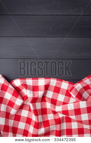 cloth napkin or  tablecloth checked at rustic wooden plank board table background, top view